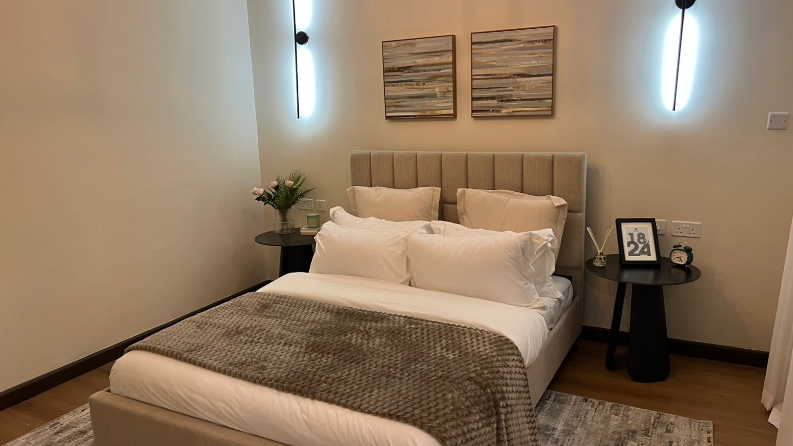 Bedroom at Beacon by Synina, Kileleshwa, with an upholstered bed, white bedding, and round black bedside tables.