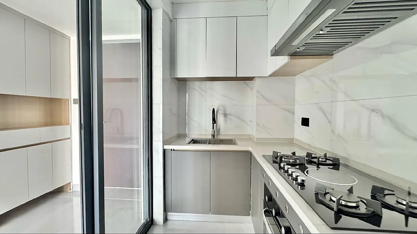 Kitchen at Capital Garden, Hurlingham, with fitted cabinets, a sink, hob, oven and extractor hood.