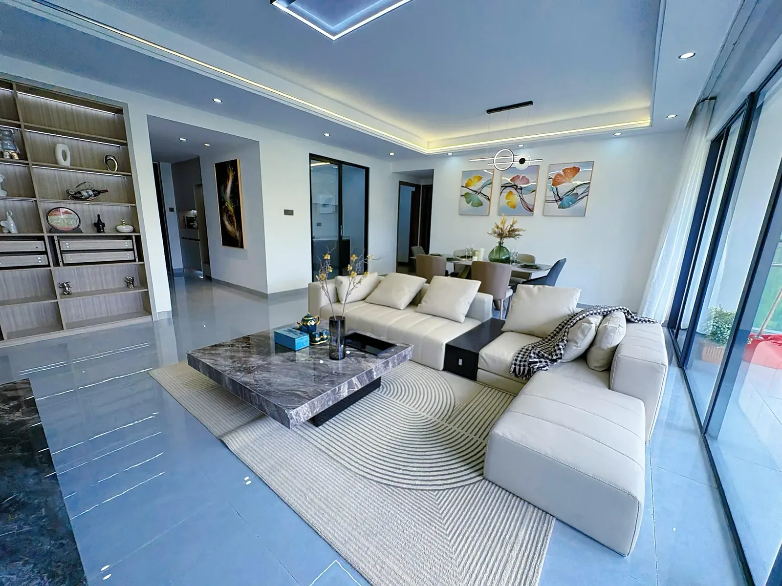 Capital Garden living and dining area with cream sofas, a coffee table and sliding glass doors.