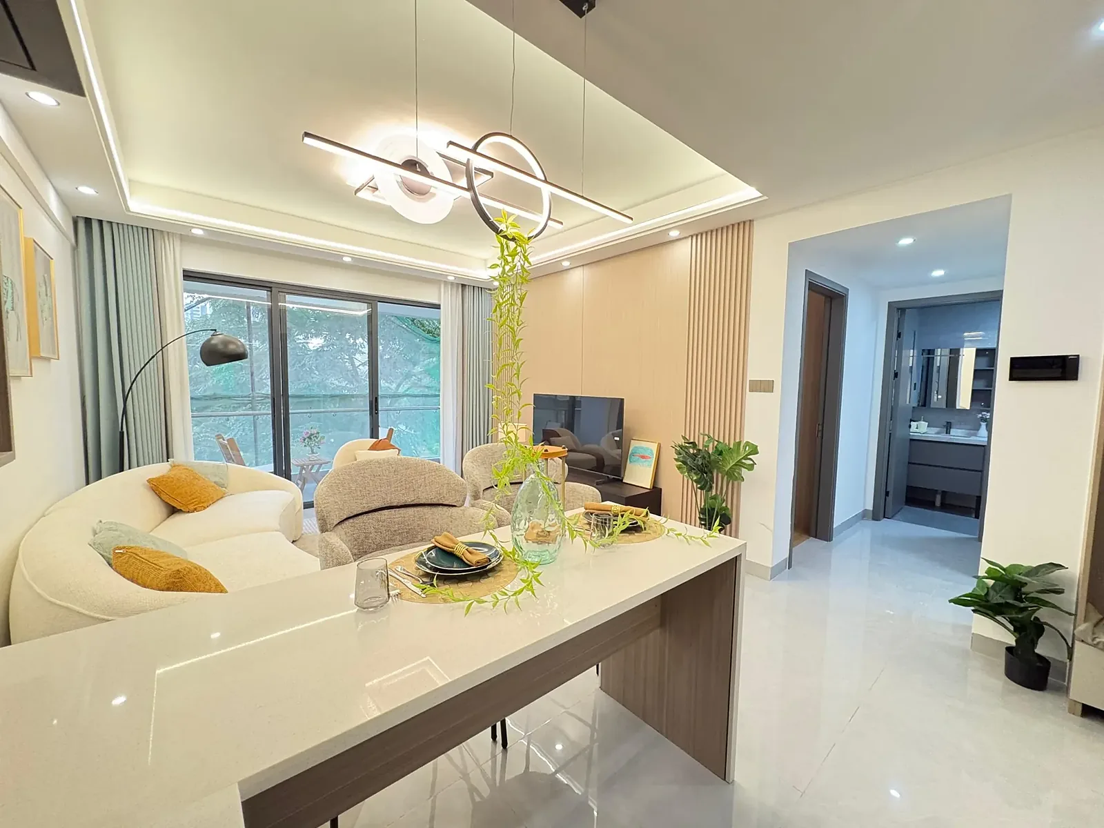 Living and dining area at Capital Garden, Hurlingham, with curved sofa and sliding glass balcony doors.
