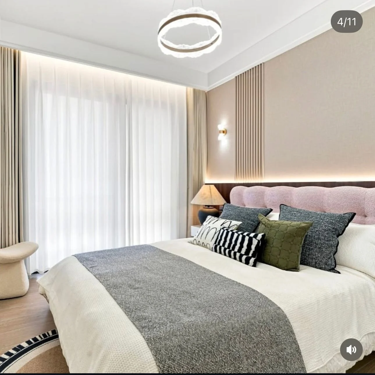 Bedroom at Capital Heights, Westlands, with a pink upholstered headboard, patterned cushions and sheer curtains.