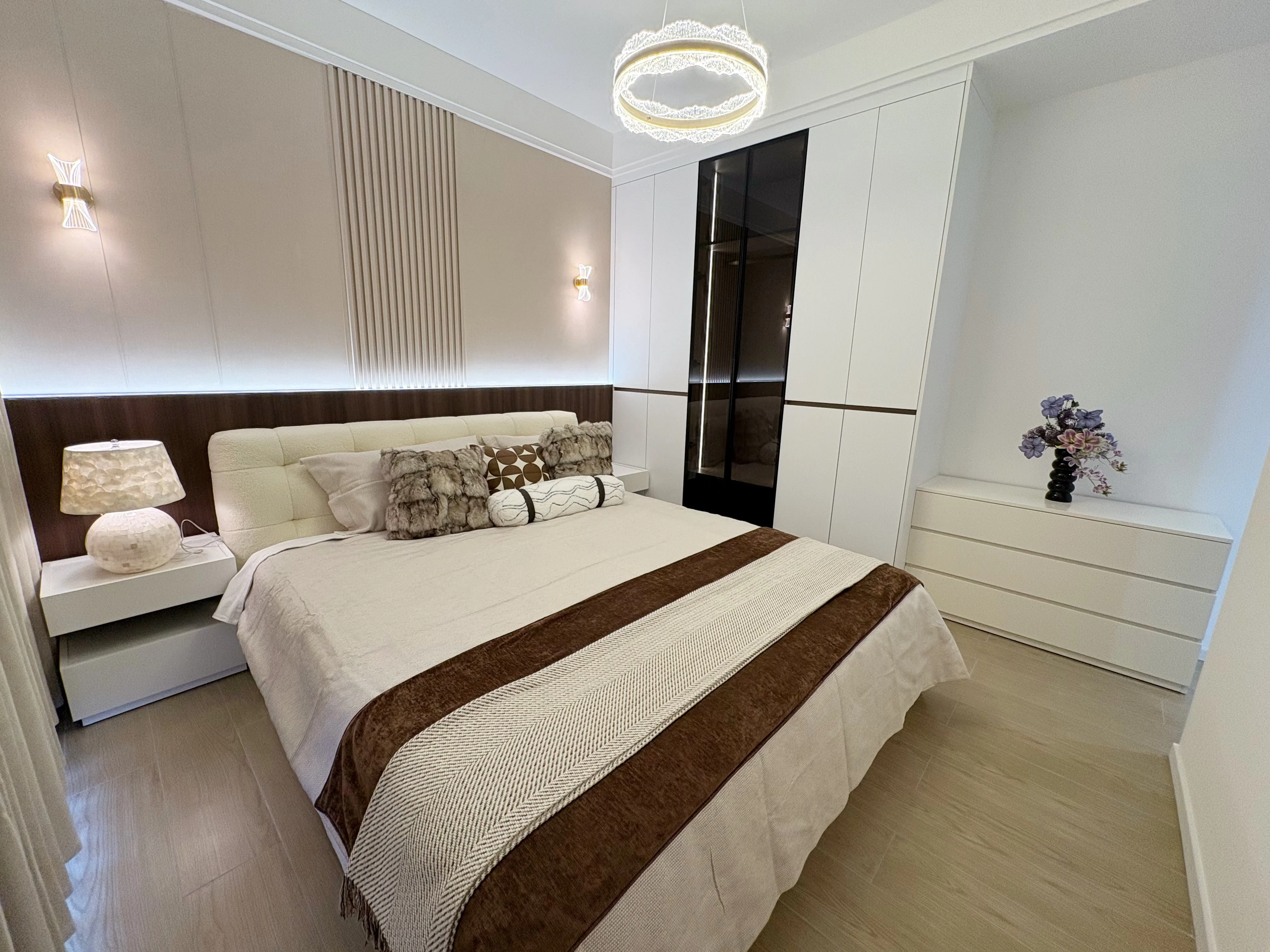 Bedroom at Capital Heights, Westlands, with an upholstered bed, white wardrobe and a circular pendant light.