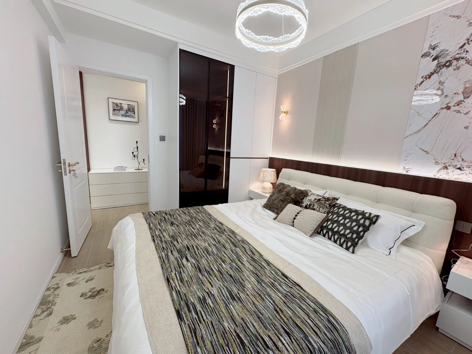 Bedroom at Capital Heights Westlands with an upholstered bed, fitted wardrobe and circular chandelier.