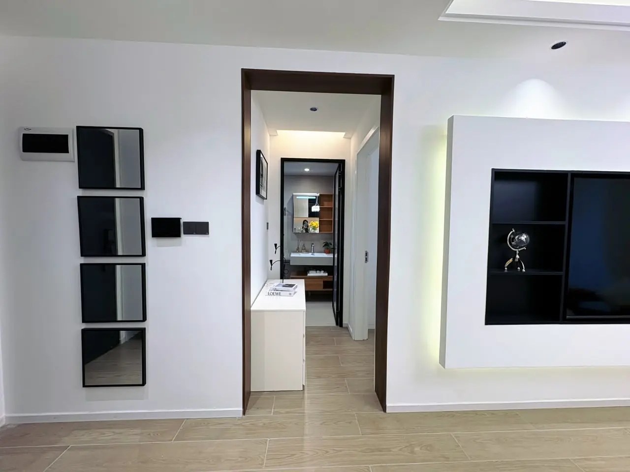 Capital Heights apartment interior in Westlands with stacked wall mirrors, a hallway doorway and recessed display shelves.