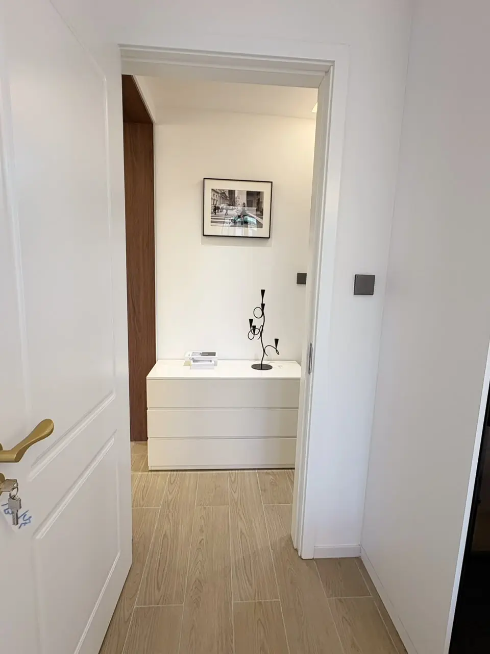Open doorway revealing a white chest of drawers and framed artwork at Capital Heights, Westlands.