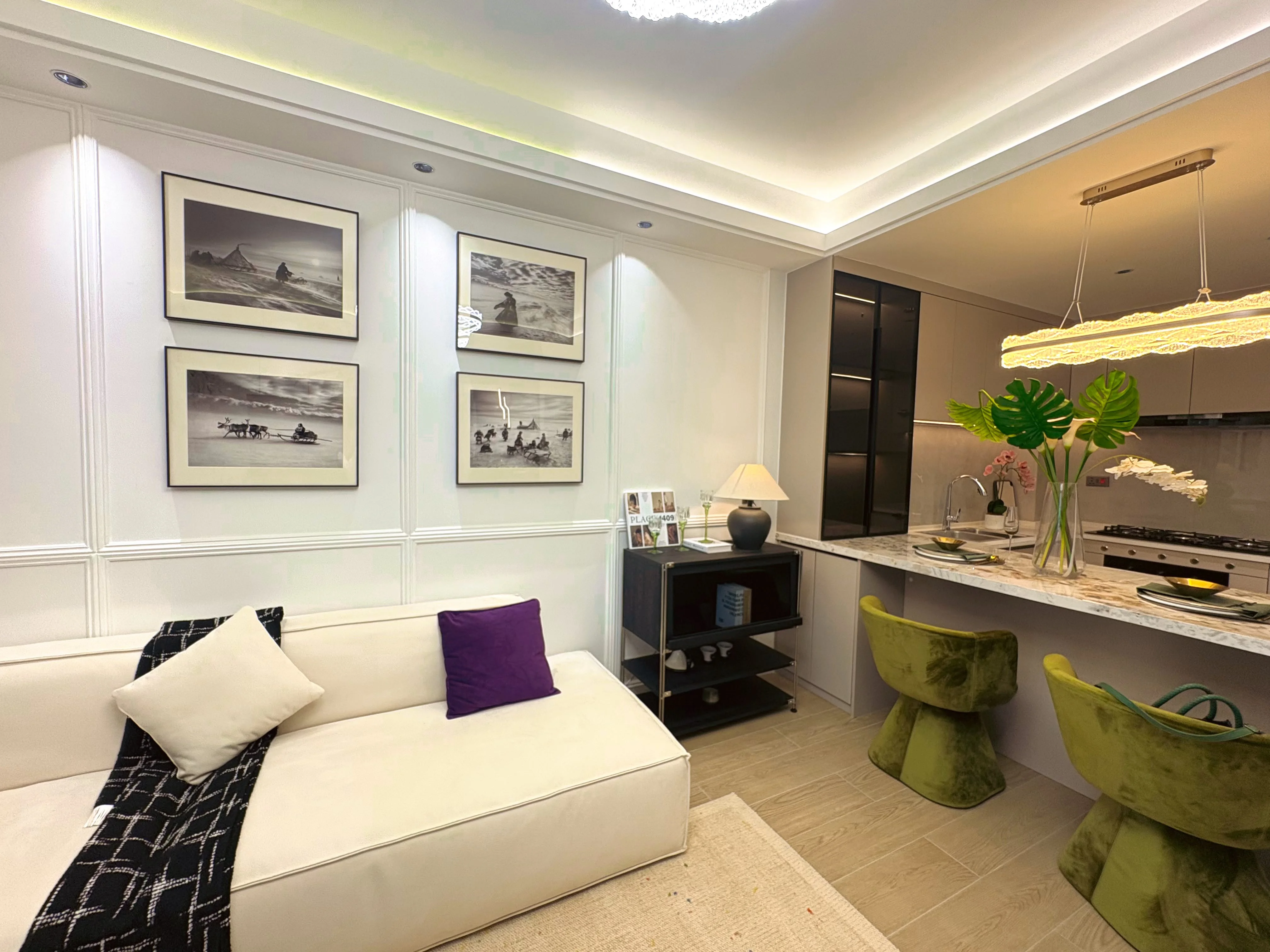 Capital Heights Westlands living area with a cream sofa, open kitchen and green breakfast bar chairs.