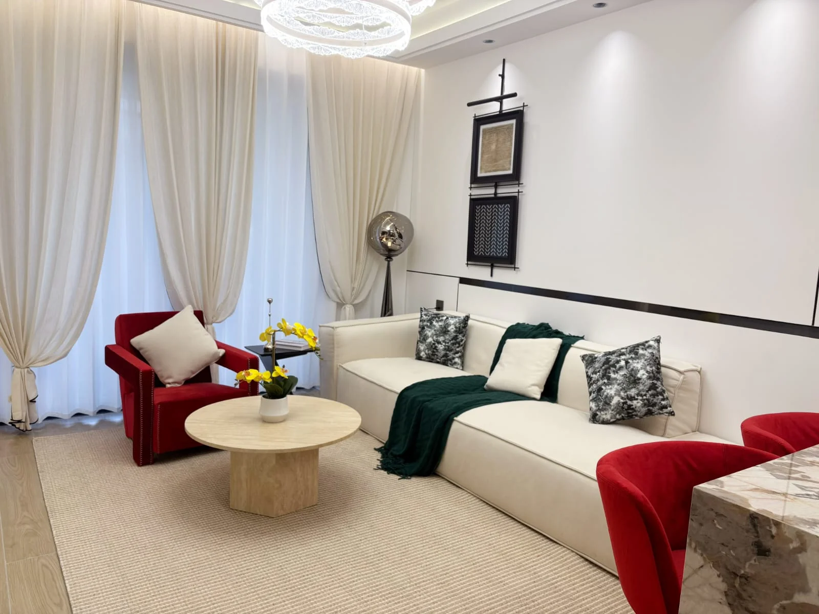 Capital Heights Westlands living room with a cream sofa, red armchair and round coffee table.