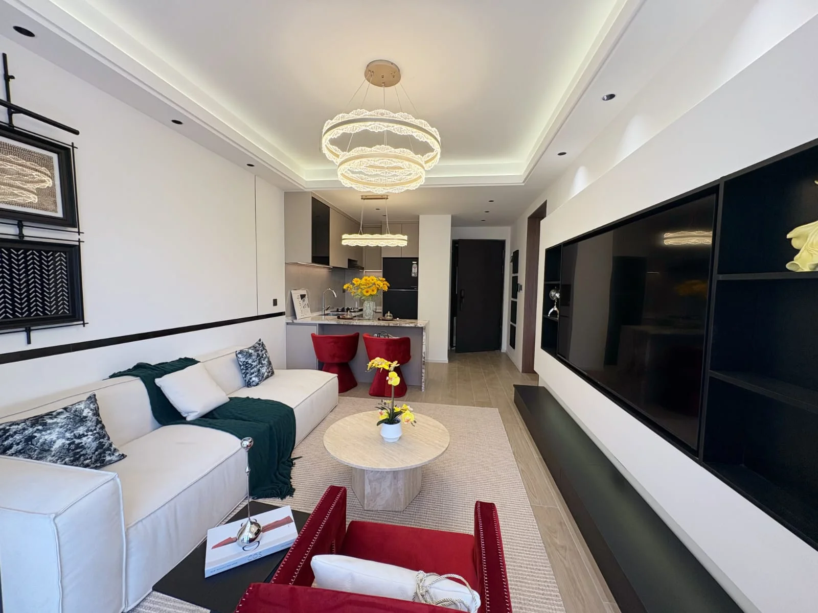 Capital Heights Westlands living room with a cream sofa, circular pendant lights and an open-plan kitchen.