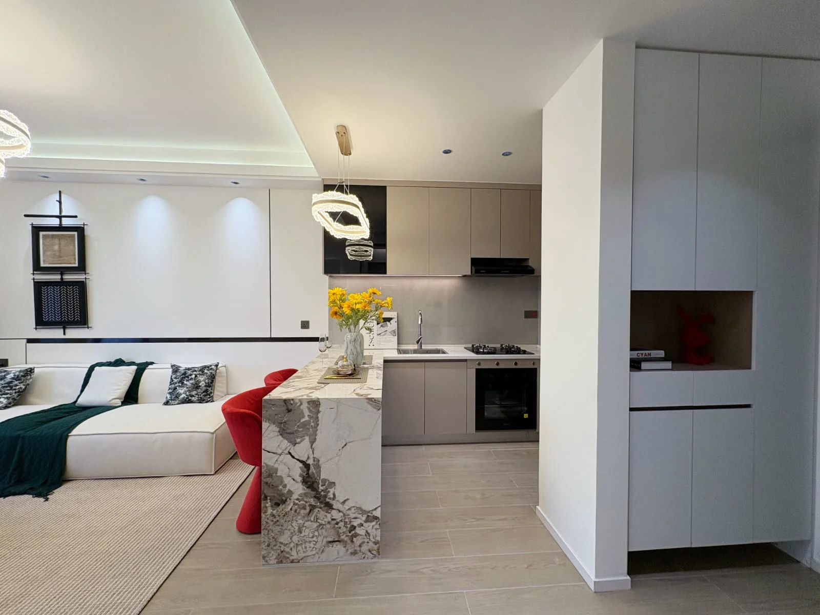 Open-plan kitchen and living area at Capital Heights, Westlands, with a breakfast bar, red stools and white sofa.