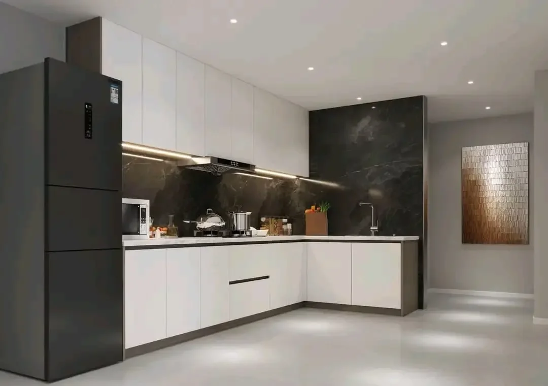 Kitchen at Citrine Heights, Westlands, with white cabinets, dark veined backsplash, a refrigerator and under-cabinet lighting.