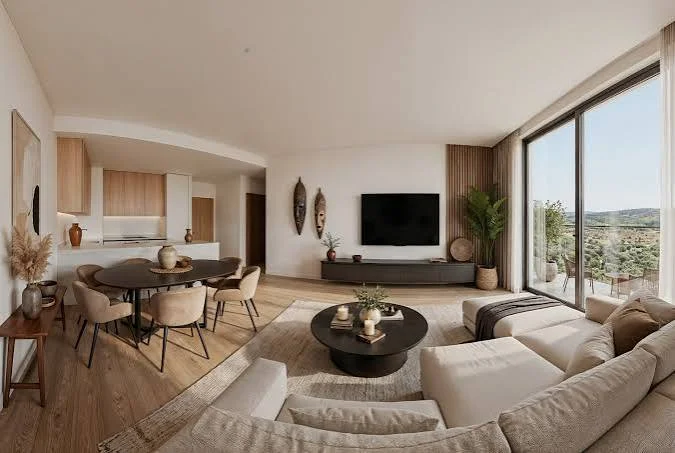 Open-plan living and dining area at Enzo Residences, with a cream sectional sofa and full-height windows.