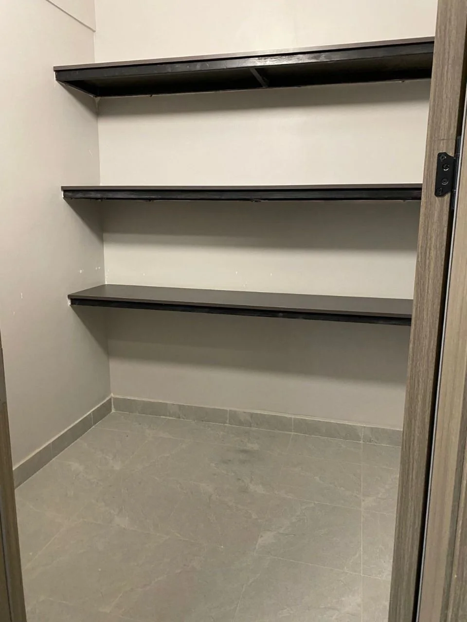 Three dark shelves and a grey tiled floor at Golden Street Residency, Kileleshwa.