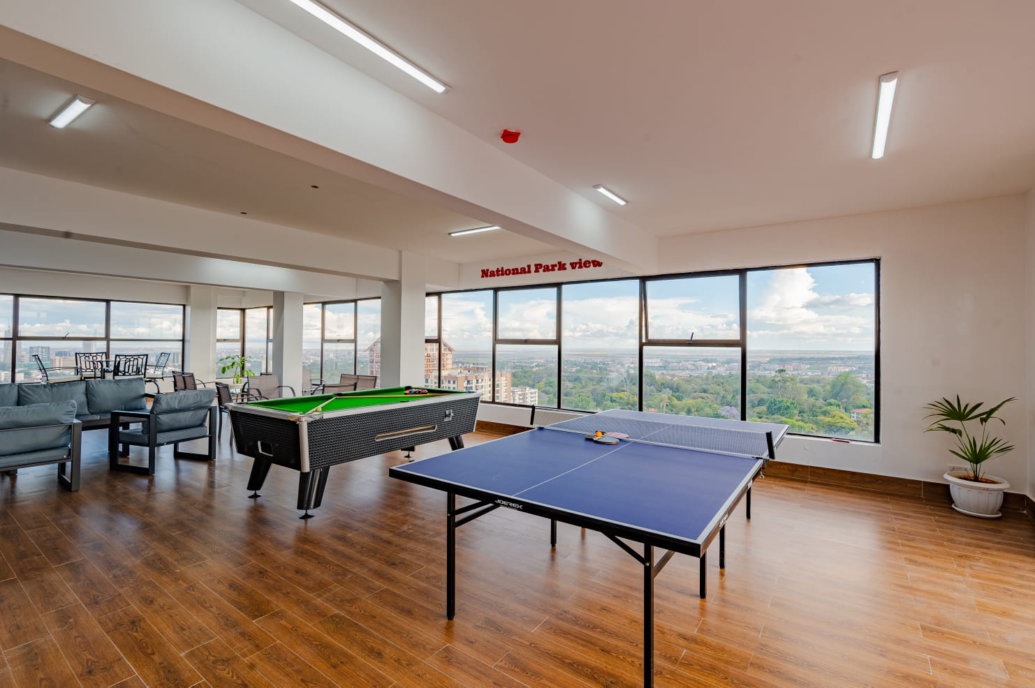 Pool and table tennis tables with lounge seating and large windows at Kilimani apartments.