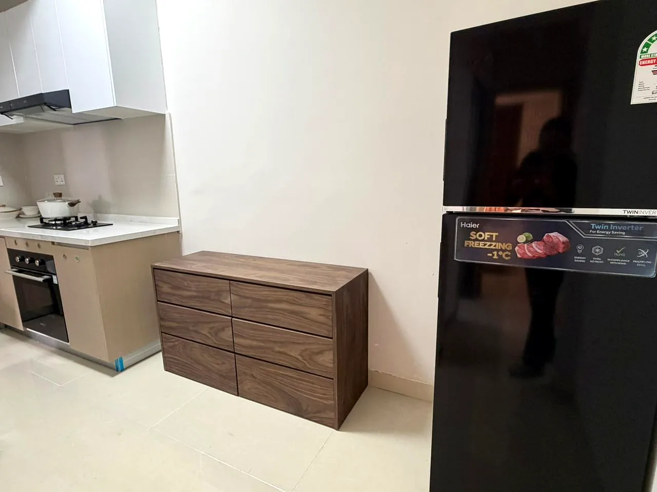 Lido Garden kitchen in Kilimani with a black refrigerator, gas hob, built-in oven and wood-effect drawer unit.