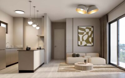 Loresho apartment living area with a cream sofa, round coffee tables and an open kitchen with pendant lighting.