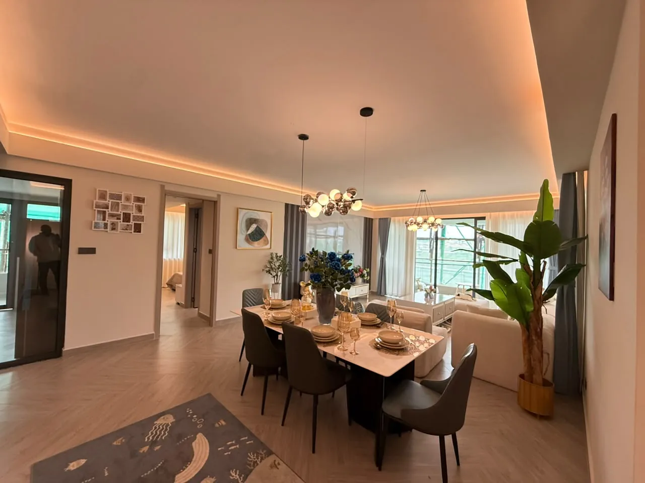Open-plan living and dining area at Mara Grove Residence, Syokimau, with a set table and pendant lights.