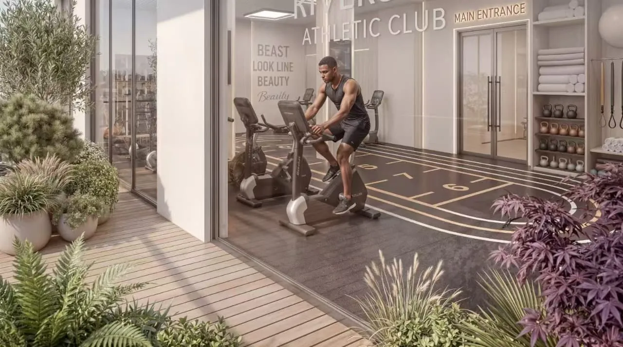 Gym rendering at Riverside Times Apartments, showing a man on an exercise bike and kettlebell shelves.