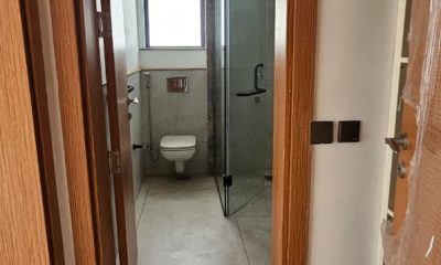 Bathroom at San Remo Heights, Westlands, with a toilet, glass shower enclosure, tiled floor and window.