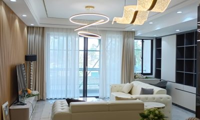 Living room at San Remo Heights, Westlands, with cream sofas, sculptural pendant lights and sheer curtains.