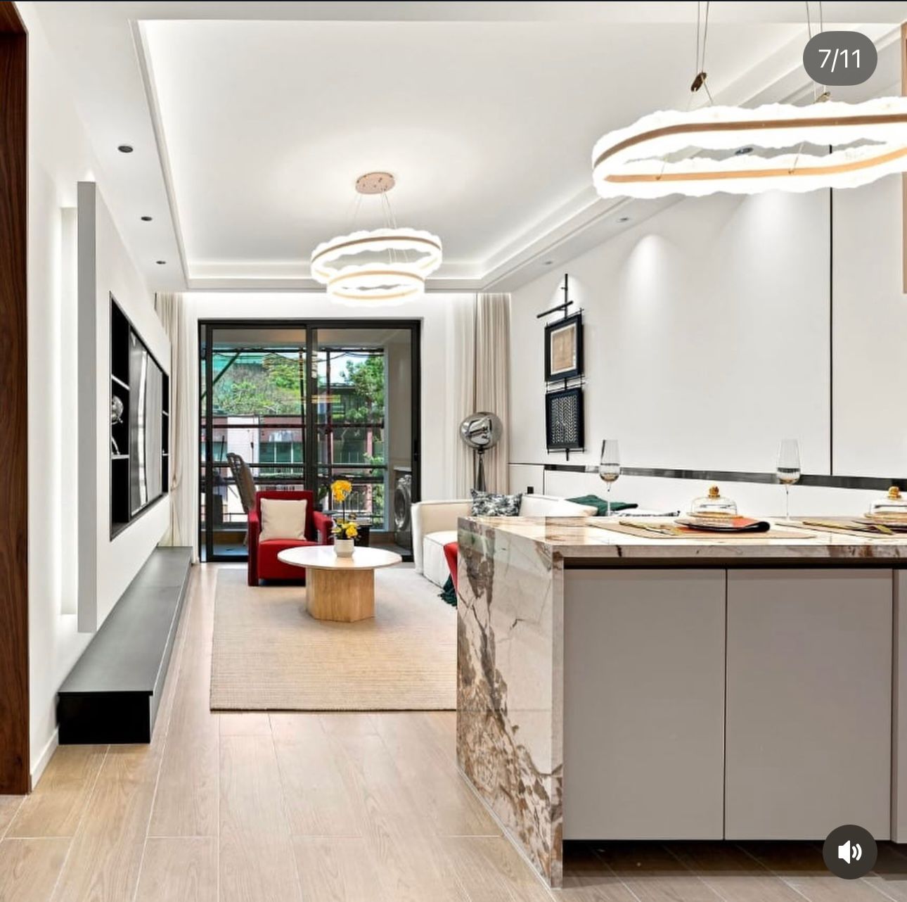 Santorini Residences Westlands living area with a dining counter, red armchair, pendant lights and sliding balcony doors.