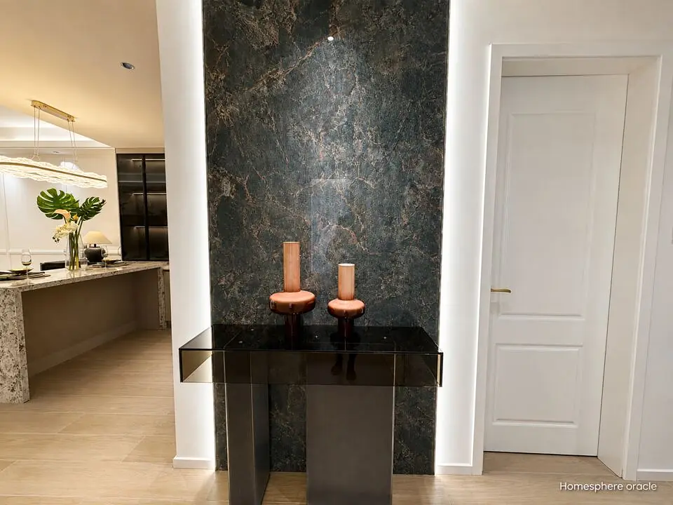 Black console table and two decorative vases against a dark veined feature wall in a Spring Valley apartment.