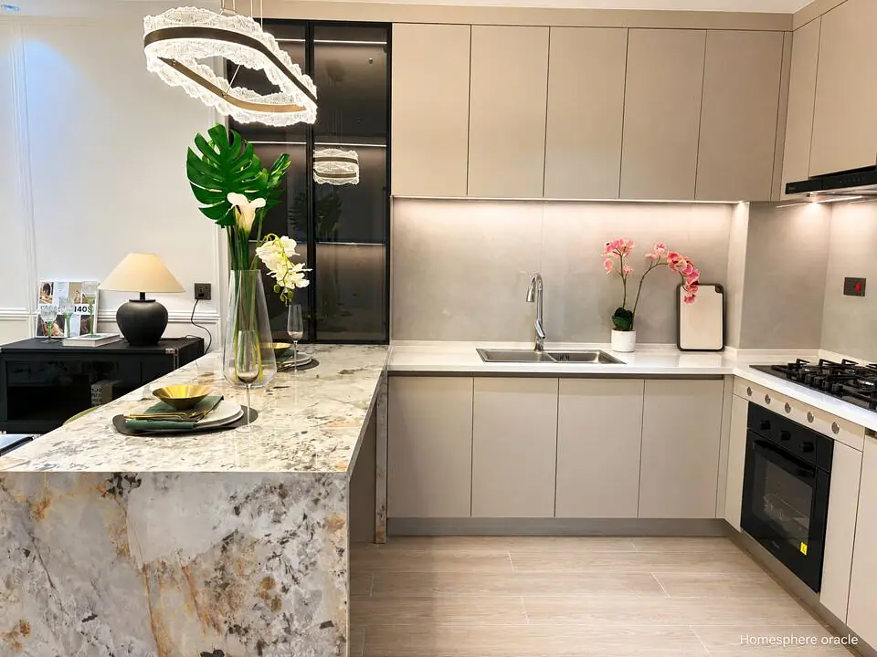 Kitchen in a Spring Valley apartment with beige cabinets, a veined breakfast bar and built-in oven.