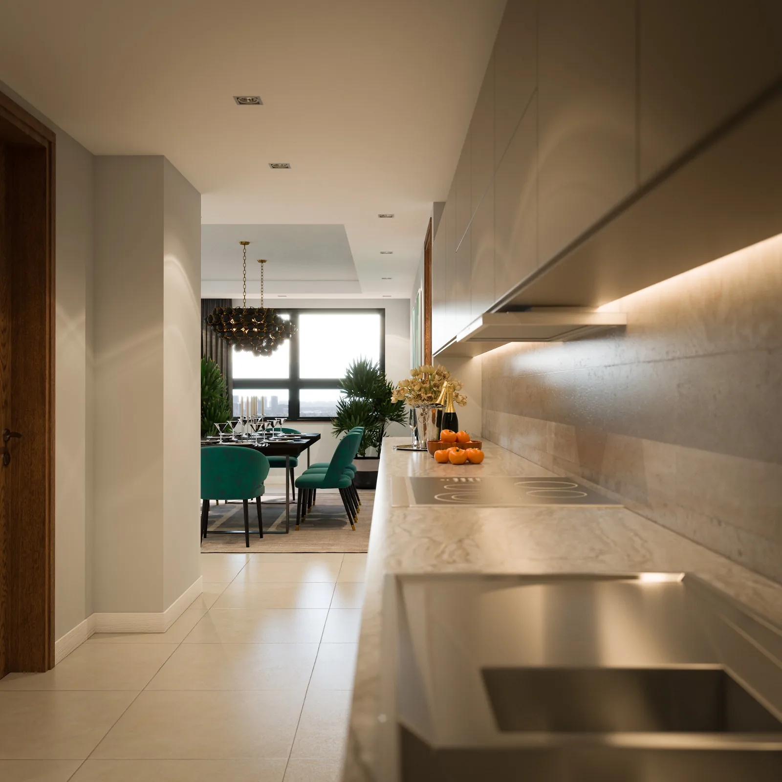 Sunstone Apartments kitchen with sink, hob and overhead cabinets, leading to a dining area with green chairs.
