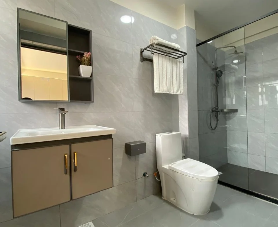 Bathroom at Super Westbury, Westlands, with a wall-mounted vanity, toilet and glass-enclosed shower.