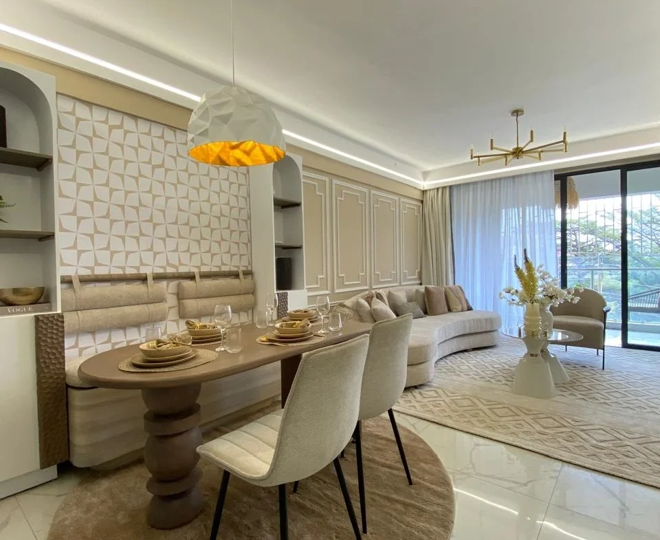 Living and dining area at Super Westbury, Westlands, with a set table, curved sofa and glass doors.