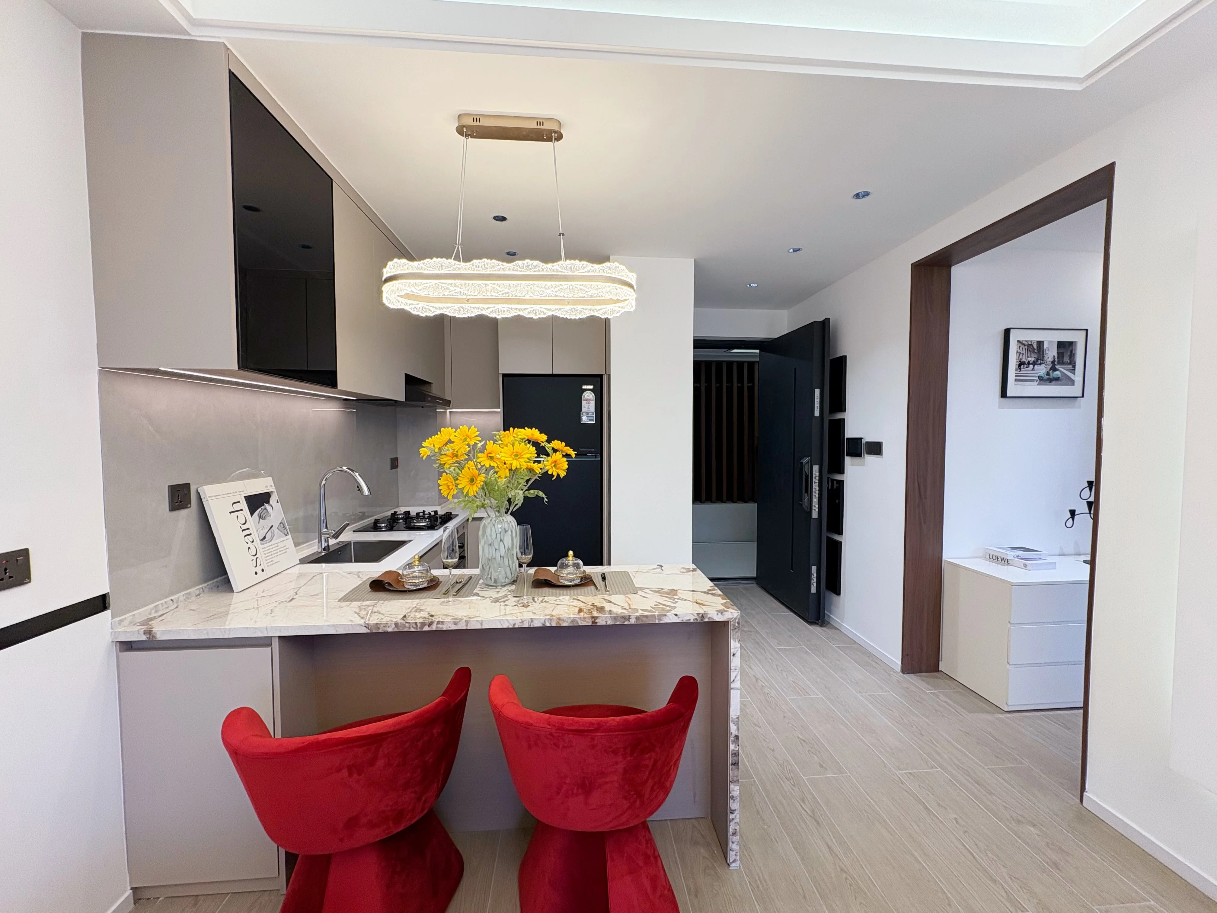 Kitchen at Versailles Garden II Kileleshwa with a breakfast bar, red chairs and pendant lighting.
