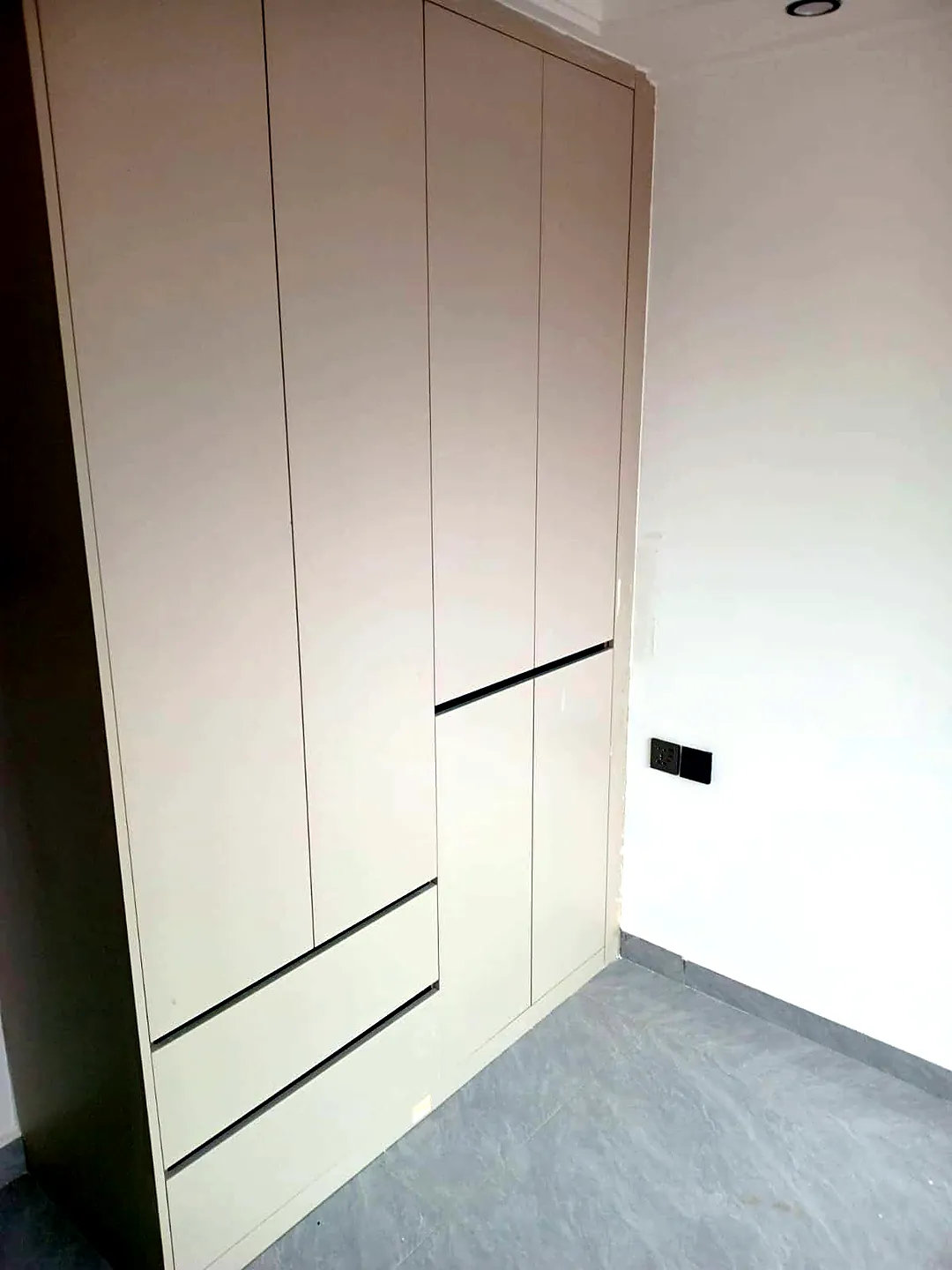 Cream built-in wardrobe with drawers and grey tiled flooring at Versailles Garden, Kileleshwa.