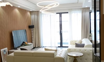 Living room at Versailles Garden, Kileleshwa, with cream sofas, a slatted feature wall and ring pendant lights.